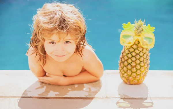Feliz chico con estilo disfruta de la vida en la piscina de verano. Fruta de piña de verano. —  Fotos de Stock