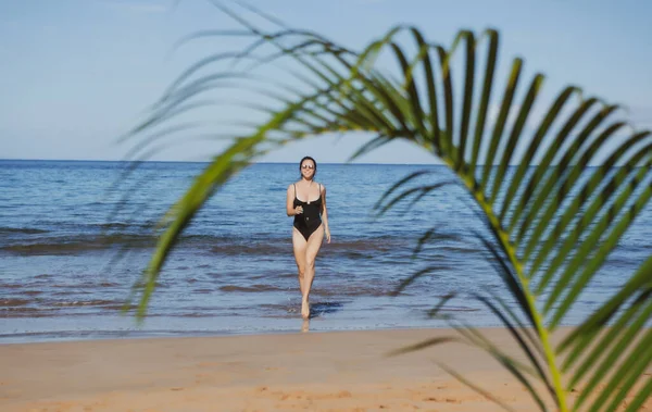 Mulher bonita correndo na praia tropical. Praia paradisíaca tropical com areia branca e palmas, conceito de turismo de viagens. — Fotografia de Stock
