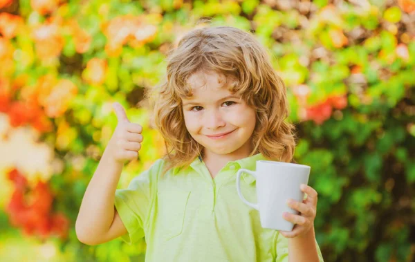 Retrato de crianças bonito com caneca, criança segurando uma grande xícara com chá de ervas. Infância feliz. — Fotografia de Stock