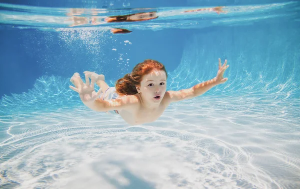 Szczęśliwy dzieciak pływa w basenie pod wodą, aktywny dzieciak pływa pod wodą, zabawy i zabawy, Dzieci sporty wodne. Wakacje z dziećmi. — Zdjęcie stockowe