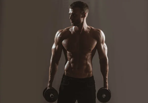 Torso desportivo, homem com halteres. Homem musculoso trabalhando fora no estúdio fazendo exercícios, forte masculino nu torso abs. — Fotografia de Stock