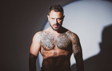 Ciddi yüzlü, kendine güvenen çekici bir adam. Kaslı atletik seksi erkek, çıplak gövde..