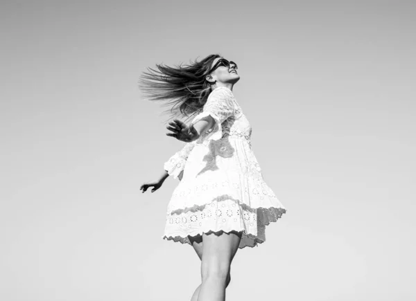 Κορίτσι της κίνησης με λευκό φόρεμα στον ουρανό. Όμορφο κορίτσι με κομψά ρούχα μόδας το καλοκαίρι. Γυναίκα της μόδας που ποζάρει. Προσεκτικές γυναίκες έξω. — Φωτογραφία Αρχείου