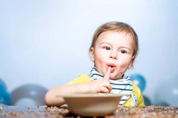 Baby 's eten, gezond voedsel voor een baby. Grappige jongen met bord en lepel. — Stockfoto