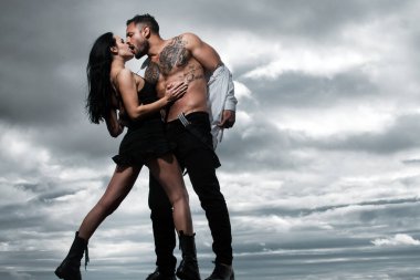 Romantik baştan çıkarma flörtü, romantik çift. Gömleksiz, kaslı bir adam ve seksi bir kadın. Aşık seksi bir çift. Şehvetli aşıklar soyunur. Kız arkadaş ve erkek arkadaş şehvetli kucaklaşmalar. Güzel çift..