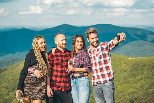 友人のグループは、山の中で自撮り。ハイカーのグループは自然の中で写真を撮ります。一緒にキャンプは楽しい、友情です。夏休みの学生は笑ったり話したり. — ストック写真