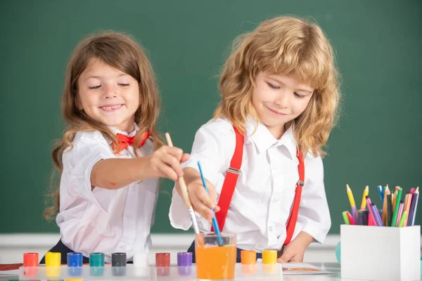 Los niños de la escuela dibujan dibujos coloridos con lápices de colores en el aula. Retrato de alumnos lindos disfrutando de clases de arte y artesanía. Arte infantil, creatividad concepto infantil. — Foto de Stock