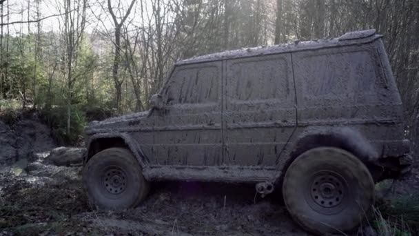Hjuldäck närbild i ett lantligt landskap med en lerig väg, smutsiga däck i lera. Terrängkörning på bergsväg. — Stockvideo