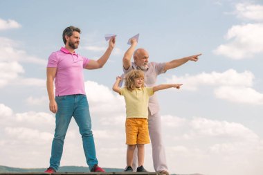 Büyükbaba ve oğul gökyüzünde oyuncak uçakla oynuyorlar. Mutlu bir aile. Üç erkek nesli. Mutlu bir çocukluk. Başlangıç, yaratıcılık başlangıç konsepti.