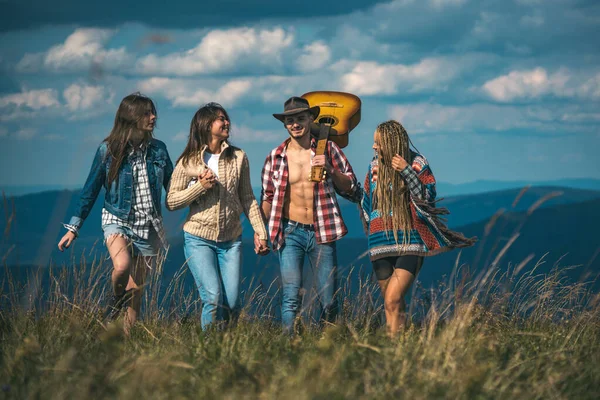 Grupo de amigos excursionistas caminando en las montañas. Grupo de jóvenes en caminata por el campo. Jóvenes haciendo senderismo en el campo, riendo y hablando. Estilo de vida saludable y ecoturismo. — Foto de Stock