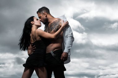Gömleksiz, kaslı bir adam öpüşen kız arkadaşını kucaklıyor. Birbirine aşık genç bir çift. Seksi, tutkulu çift kucaklaşması. Duygusal çift stüdyoda birlikte poz veriyor. Yakışıklı Latin ve İspanyol aşıklar..
