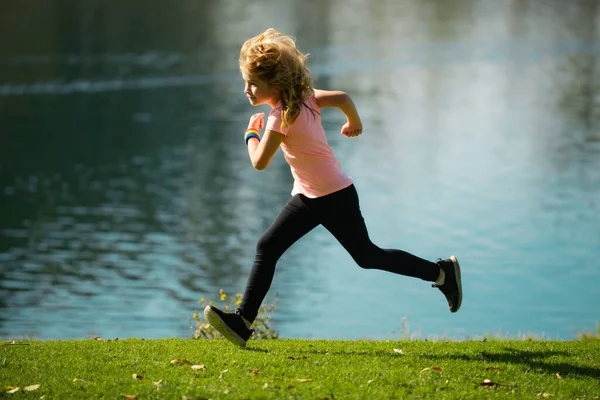 밖에서 뛰고 있는 소년. 여름 공원에서 뛰어다니는 꼬마. 아침 조깅. — 스톡 사진