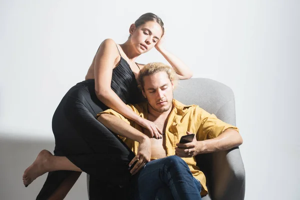 Fashion elegant stylish couple in love looking on each other with pleasure. Sensual woman with her boyfriend posing on gray studio background. Trendy look. — Stock Photo, Image