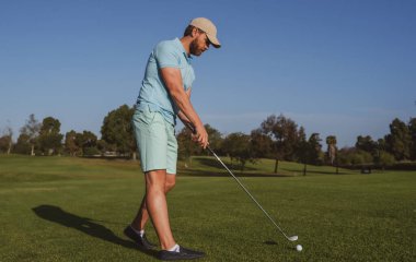 Golf oyuncusu güneşli bir günde golf oynuyor. Profesyonel golfçü golf sahasında vuruldu..