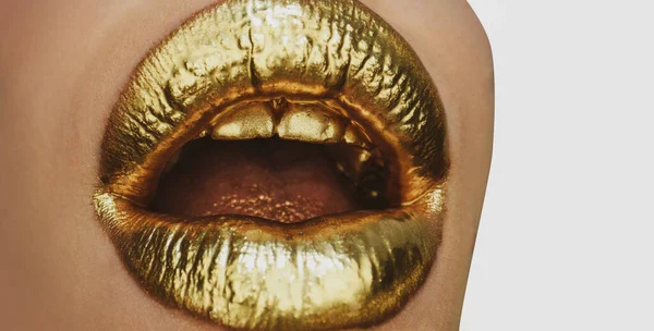 Open golden mouth. Gold lips lipstick and gloss. Sexy and sensual lips. Golden lips closeup. Golden art design.