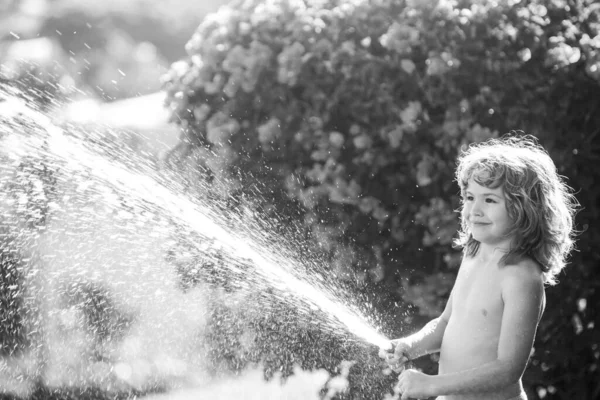 Очаровательный маленький мальчик поливает растение за пределами дома, концепция растениеводства учебной деятельности для детей и детского образования для дерева в природе. — стоковое фото