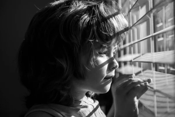 아이가 창문을 내다보고 있습니다. Qarantine 컨셉. 자신을 보호하 십시오. 집에 혼자 있어. COVID-19 록 다운. 코로나 바이러스 유행병. — 스톡 사진