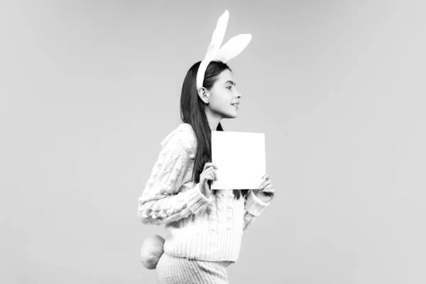 Fille en costume lapin de Pâques tenir du papier sur fond bleu isolé . — Photo