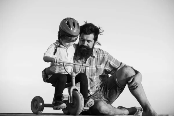 Vater bringt Sohn Fahrradfahren bei. Glücklicher Papa hilft aufgeregtem Sohn beim Fahrradfahren. Vertrauen und Unterstützung. Das Gefühl der Unterstützung durch Eltern, Eltern. Vatertag. — Stockfoto