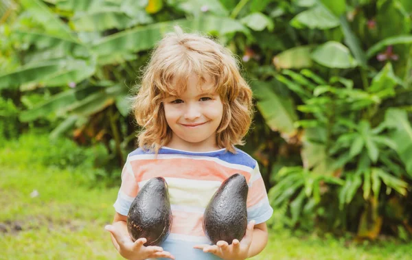 Niños lindo o niño niño sonrisa y celebración de fruta de aguacate. —  Fotos de Stock
