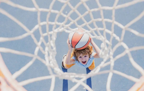 Jogo de basquetebol. Kid treinamento com bola cesta na quadra de basquete ao ar livre. — Fotografia de Stock