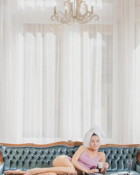 Fille reposant et couché dans un canapé-lit confortable dans la chambre de luxe un matin facile. Belle femme sexy relaxante portant des peignoirs et des serviettes à l'hôtel. — Photo