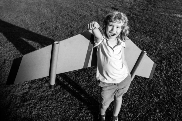 子供のリーダーと勝者、成功が始まります。興奮した子供男の子遊びますともにおもちゃジェットパック翼スーパーヒーローで公園. — ストック写真