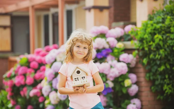 Екологічний будинок у дитячих руках на задньому дворі. Щасливий будинок мрії . — стокове фото