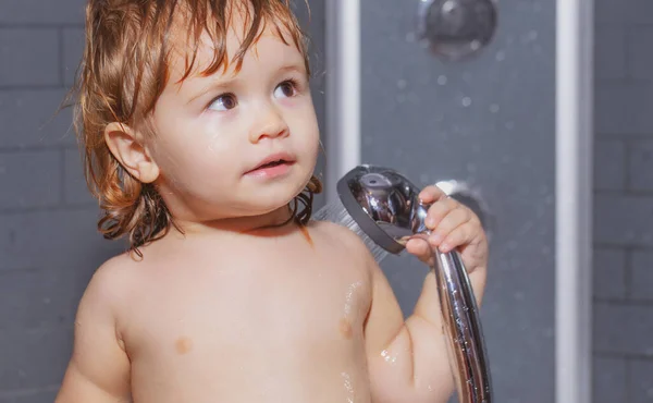 Leuk kind dat in bad speelt. Schattige baby jongen genieten van bad en gebaad in de badkamer. — Stockfoto