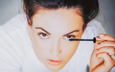 Güzel bir kadın modelin güzel portresi. Güzel genç kız ya da kahverengi gözlü kadın maskarayla makyaj yapıyor..