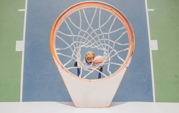 Ten kluk hraje basketbal. Veselý chlapec basketbalista drží míč. — Stock fotografie