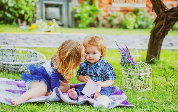 Des enfants pirates. Portrait de mignon petit garçon caucasien s'amusant dans le jardin. Les mignons enfants adorent. Petite fille embrassant petit garçon à l'extérieur dans le parc. Enfant sur pelouse d'herbe verte pendant la promenade dans la cour. — Photo