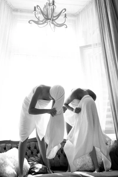 파자마의 아침 레저 시간에 집 침실에 있는 웃긴 젊은 여성. 하얀 수건 과 수건을 두른 흥분 한 친구들 이 침실에 있다. — 스톡 사진