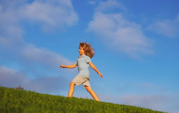 Yaz, çocukluk, boş zaman ve insan konsepti. Yeşil yaz tarlasında yürüyen mutlu küçük çocuk. Doğadaki çocuk aktiviteleri. — Stok fotoğraf