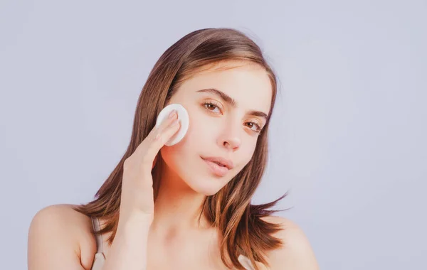 Cara de cerca de la hermosa mujer joven con almohadillas de algodón, esponja, bola de algodón. Cuidado de la piel y concepto de belleza. Chica elimina el maquillaje con bola de algodón de la cara. Concepto de cuidado de la piel. Mujer usando algodón. —  Fotos de Stock