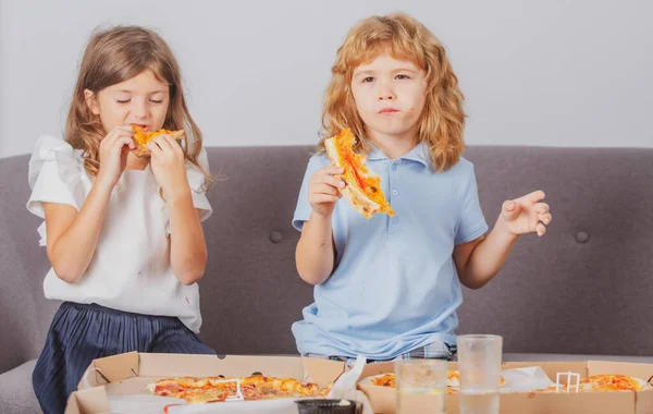 Pizza y niños, rebanadas de pizza en la mano de los niños. Niños niña y niño comiendo sabrosa pizza de comida rápida con queso. Pizza a domicilio, tiempo feliz para amigos hambrientos niños en familia. — Foto de Stock