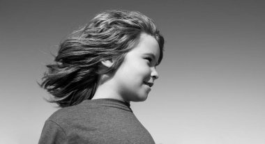 Mavi gökyüzünde fotokopi alanı olan komik çocuk suratı. Yaklaş. Çocuklar başlarını çeviriyor..