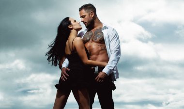 Moda aşıkları öpüşüyor ve sarılıyor. Romantik çift randevusu. Birbirine aşık bir çift. Atletik tişörtsüz, kaslı bir adam öpüşüyor ve romantik bir kadını kucaklıyor. Hassas tutkuda seksi, zarif bir çift..