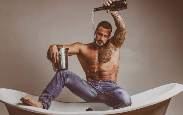 Hombre sexy en la bañera con champán. Celebrando Navidad o cumpleaños. Fiesta de sexo privado. — Foto de Stock