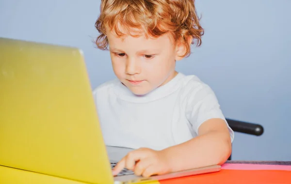 Een jongen met een notitieboekje. Een close-upportret van een slimme peuter met laptop. Kind van de basisschool. Vrolijk kind gebruik laptop computer. — Stockfoto