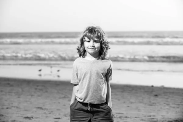 Cute kid boy walking the sea beach with hand in pocket. — Stock Photo, Image