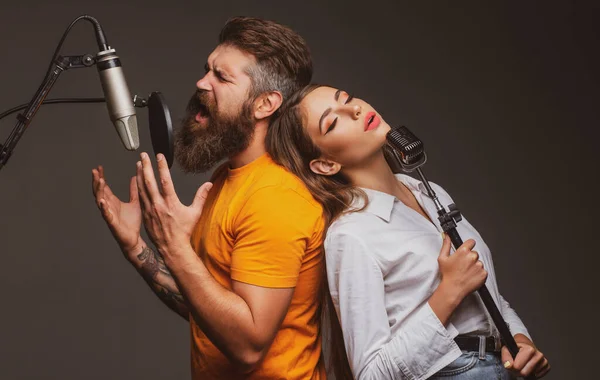 Zpívající muž v nahrávacím studiu. Výrazný pár s mikrofonem. Karaoke duet signers, hudební zpěvák. — Stock fotografie