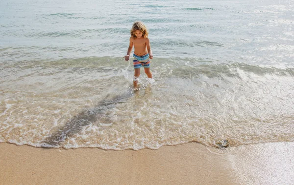 Boy kid jumping in sea waves. Jump by water sea splashes. Summer kids vacation. — Stock Photo, Image