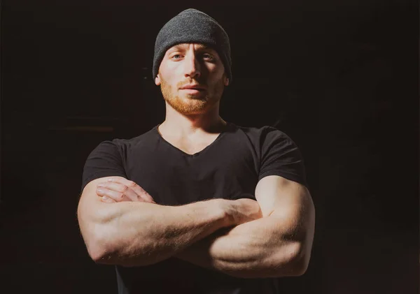 Retrato de primer plano de un hombre guapo con brazos cruzados en un estudio negro. —  Fotos de Stock