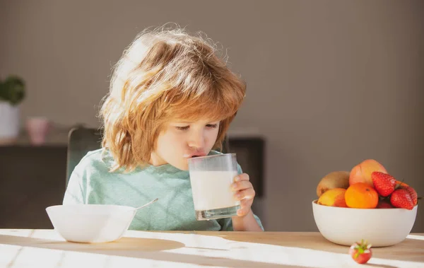 孩子们喝着牛奶杯。一个可爱的小男孩用玻璃杯里的维生素钙喝着美味的有机牛奶。幼儿享受美味的无营养乳糖酸奶.保健概念. — 图库照片