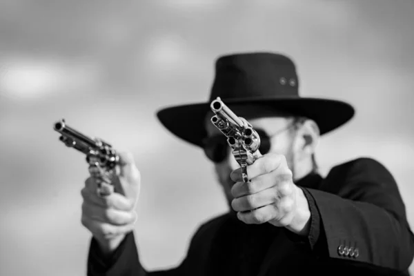 Sheriff in black suit and cowboy hat shooting gun, close up western portrait. Wild west, western, man with vintage pistol revolver and marshal ammunition. — Stockfoto