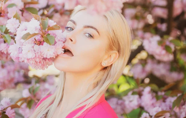 Gyönyörű lány rózsaszín virágokkal a virágos parkban. A tavasz cseresznyevirága, — Stock Fotó