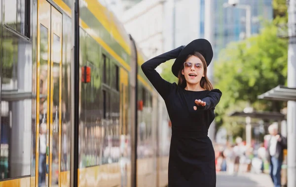 美丽的年轻女子在城市街道上追着无轨电车。漂亮的年轻时尚女人。在城市里旅行. — 图库照片