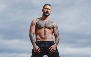 Acımasız bir adam, yakışıklı, ciddi bir erkek model. Dövmeli ve zarif bir hippi. Güçlü kaslı erkek vücudu, kaslı adam..