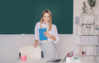 Okul sınıfında okuyan genç, kendinden emin ve çekici bir kız öğrencinin portresi. Öğrenim ve eğitim kavramı.